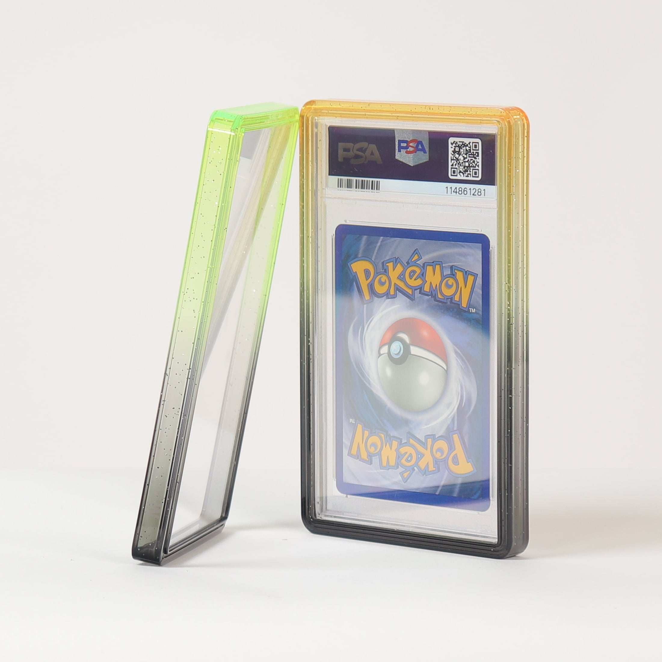 A graded Pokémon TCG card in a clear plastic slab with a yellow-orange border, standing upright next to its green-tinted protective case on a clean white surface against a white background.